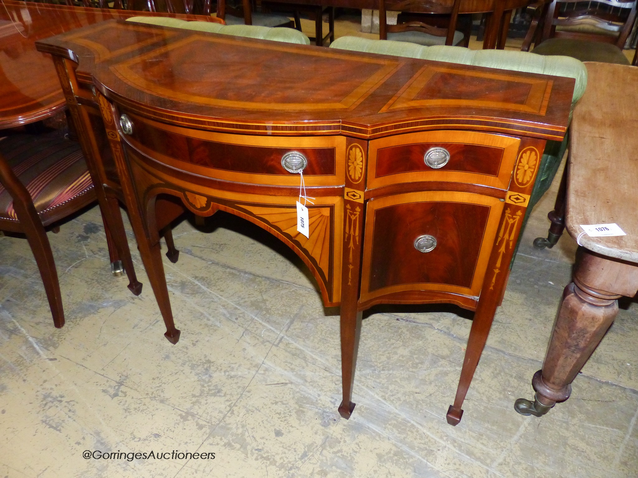 A reproduction Sheraton inlaid mahogany dining room suite, comprising twin pillar extending dining table, 240cm extended, one spare leaf, ten chairs, two with arms and sideboard. W-124, H-72cm.